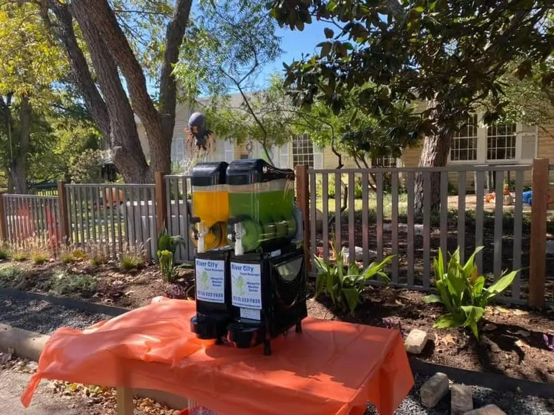 Margarita machine on a party table in a backyard garden